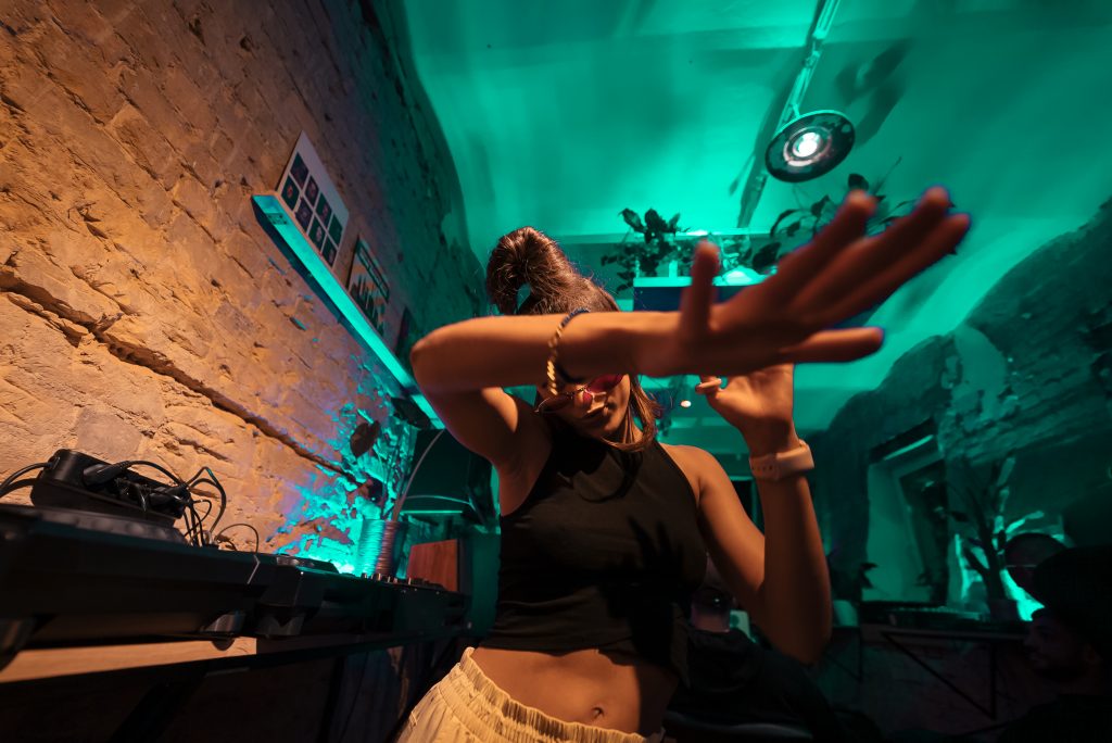 Beautiful female DJ dancing to techno in a small club in durban South africa at a Lovedurban.co.za club night in Durban South Africa from the what's on in Durban events calendar on our website
